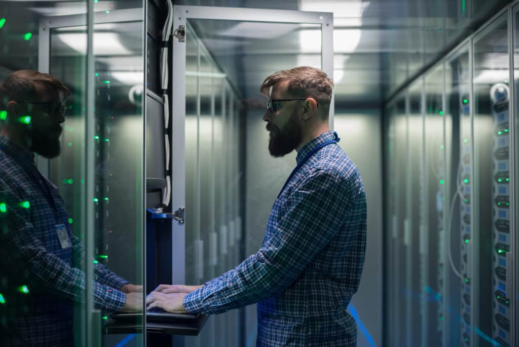 bearded IT specialist setting servers in Connecticut data center