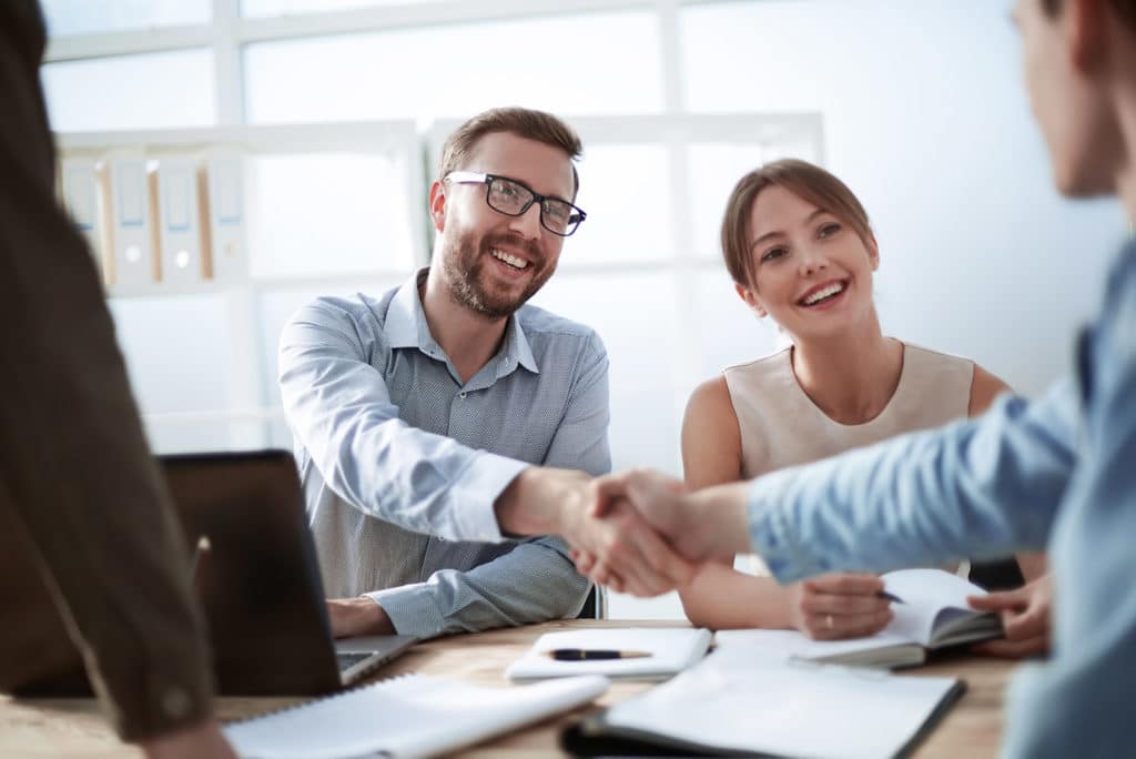 men shake hands in business meeting at IT company