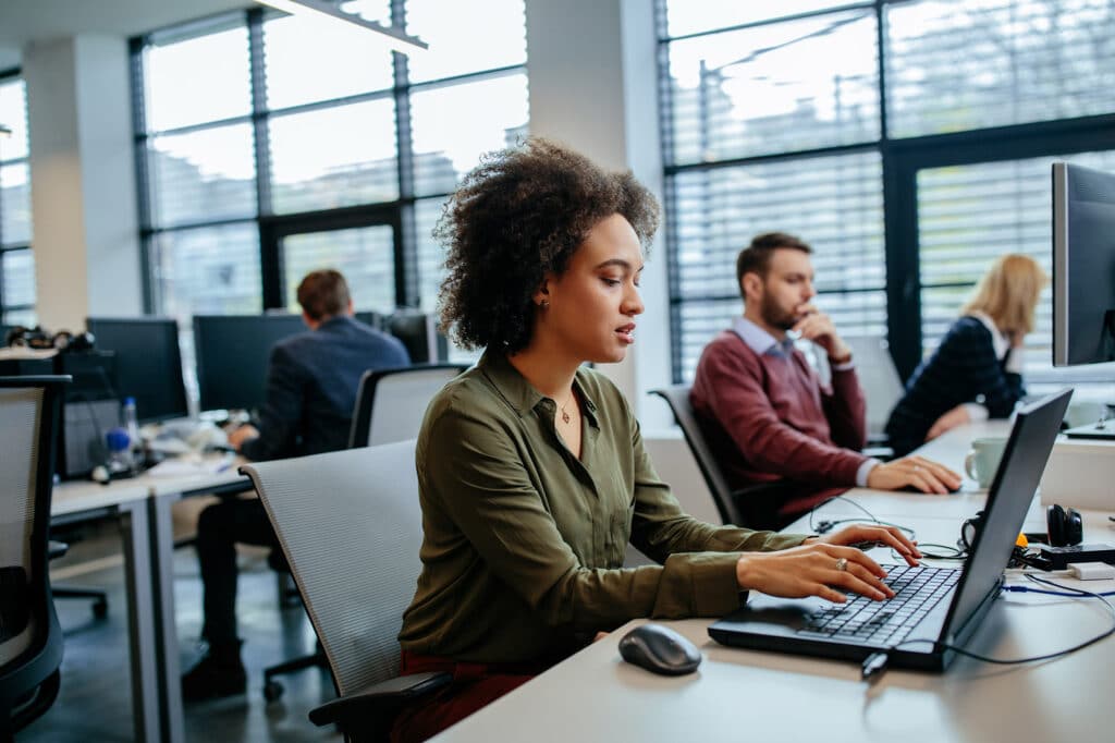 IT services company employees work at table in office