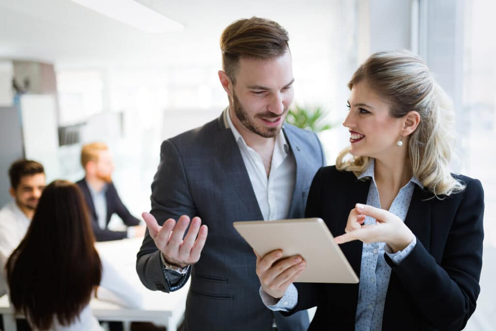 colleagues discuss tablet at a Stamford IT company