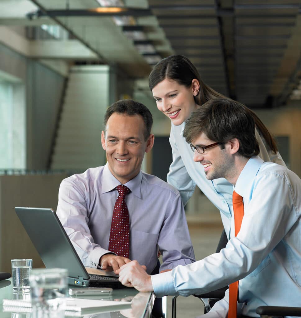 three it consultants looking at a laptop